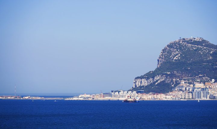 Scenic view of the iconic Rock of Gibraltar, with clear blue sky and sea, ideal for travel imagery.