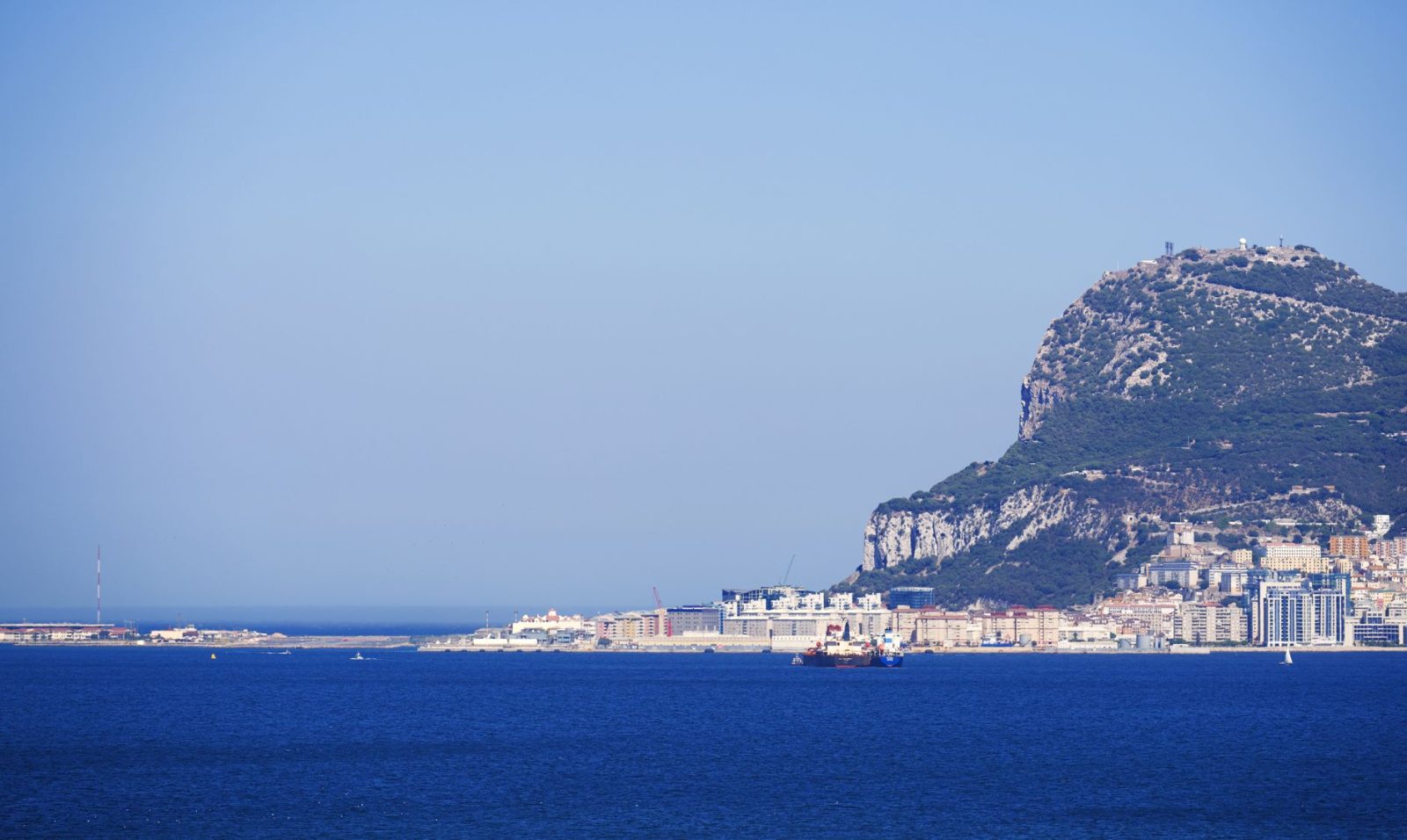 Scenic view of the iconic Rock of Gibraltar, with clear blue sky and sea, ideal for travel imagery.